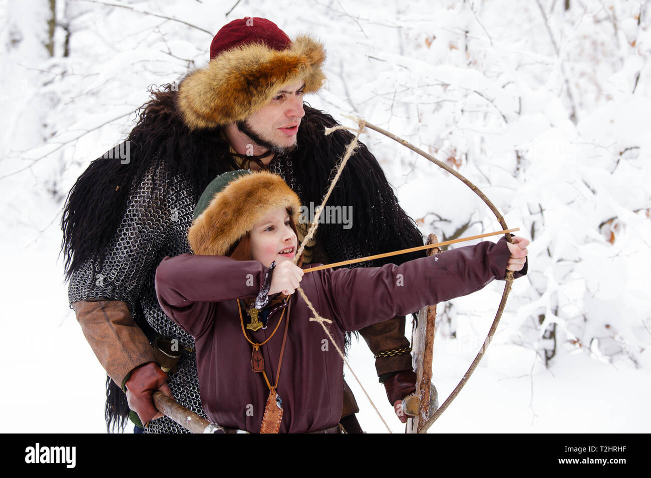 Viking warrior with chain mail leather spear walking in winter woods