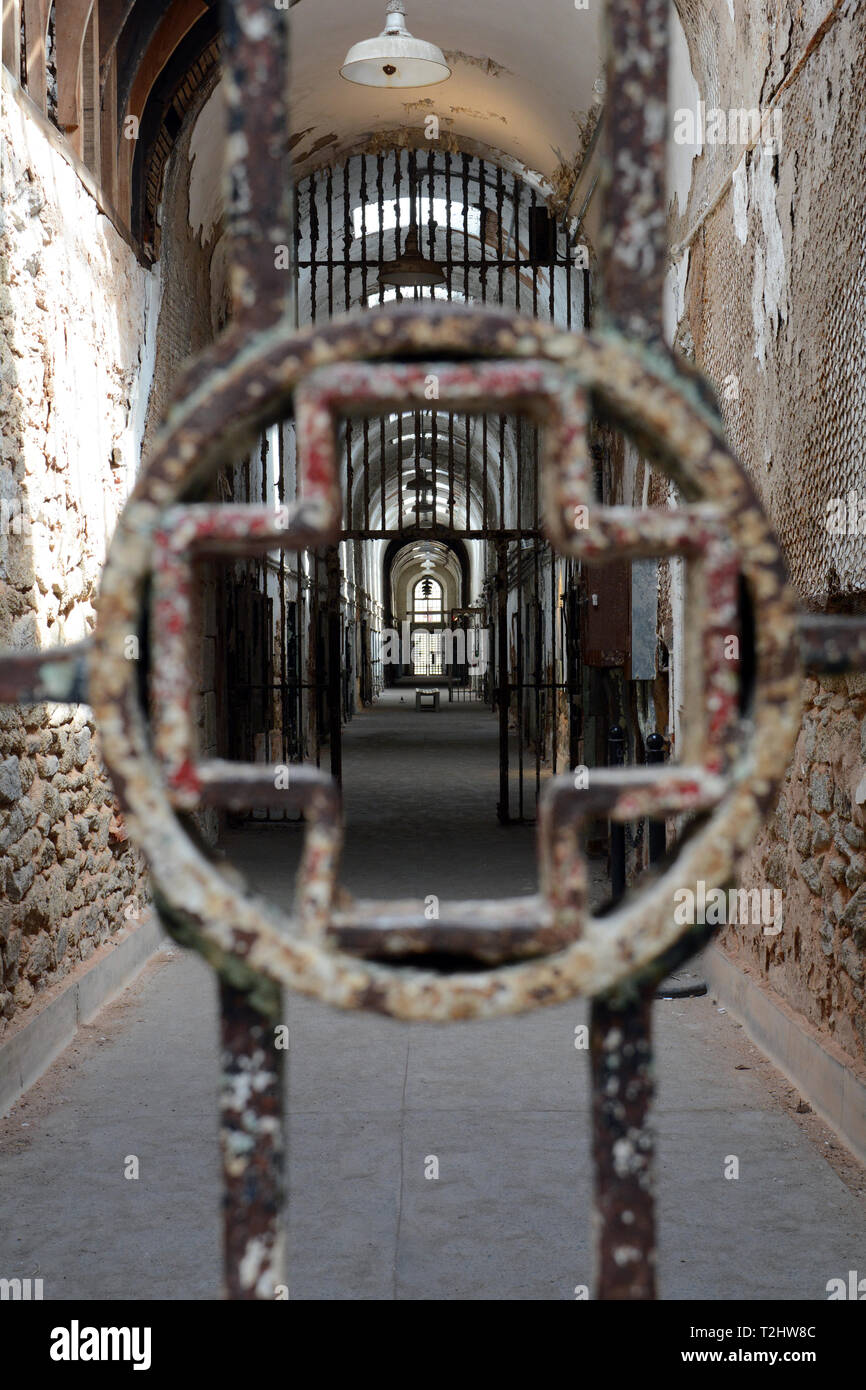 View Through Medical Cross Symbol in the Bars of an Abandoned Prison Hospital Cell Block at Eastern State Penitentiary Stock Photo