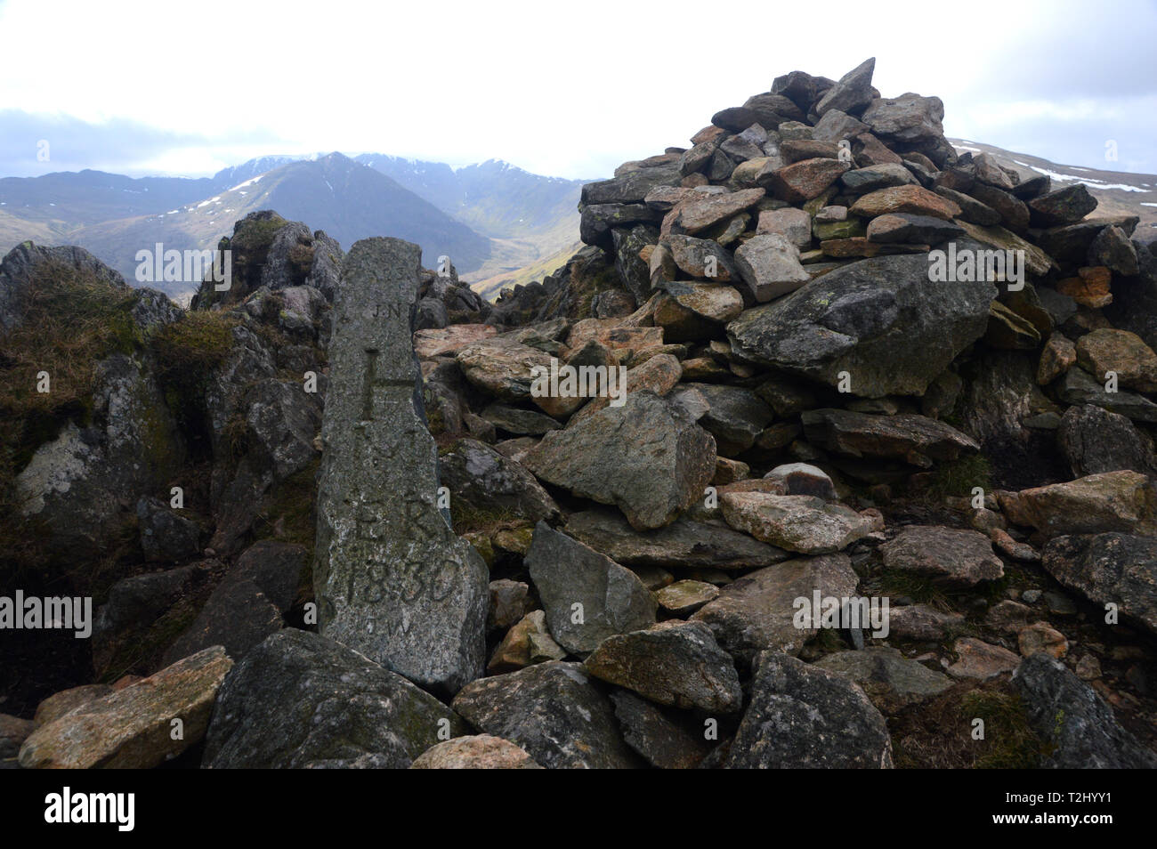 Broken Old Estate Boundary Stone and a Pile of Stones the Summit of the Wainwright Sheffield Pike in the Lake District National Park, Cumbria, UK. Stock Photo