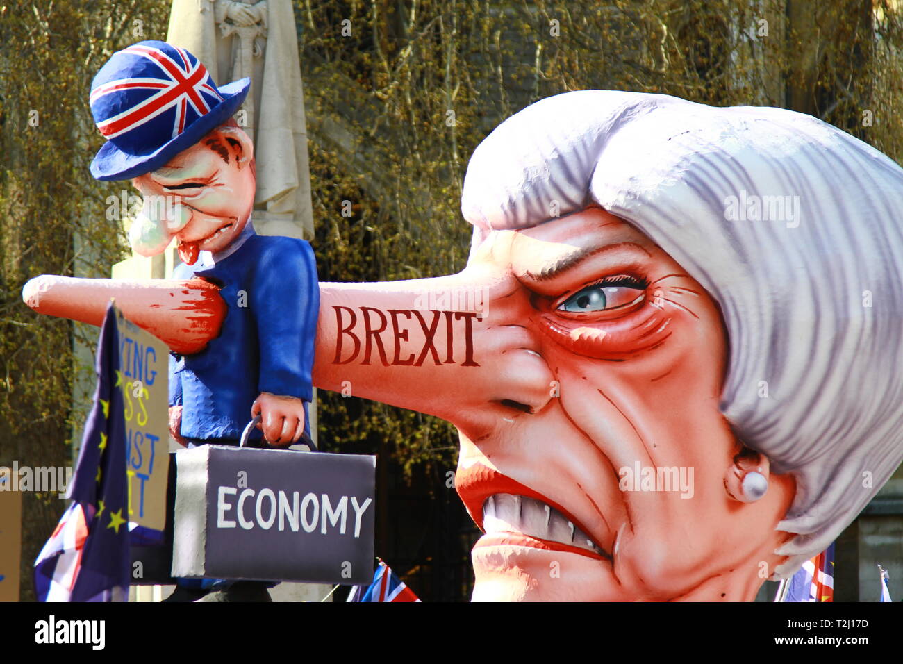 DEAL FOR THE ECONOMY. DEAL WITH JEREMY CORBYN. THERESA MAY DEAL WITH CORBYN. STOP BREXIT PROTEST OUTSIDE PARLIAMENT WESTMINSTER. POTENTIAL RECESSION BY THERESA MAY'S CONSERVATIVE GOVERNMENT. DESTRUCTION OF THE ECONOMY BECAUSE OF BREXIT. LEAVING THE EUROPEAN UNION ON THE 29TH MARCH 2019. NO DEAL. CRASHING OUT WITHOUT A DEAL. WTO RULES.  MODEL DEPICTS THRESA MAY'S NOSE STABBING A CITY GENT THROUGH HIS BACK. MAN STABBED FROM BEHIND. BREXIT. NO DEAL IS BETTER THAN A BAD DEAL. Stock Photo