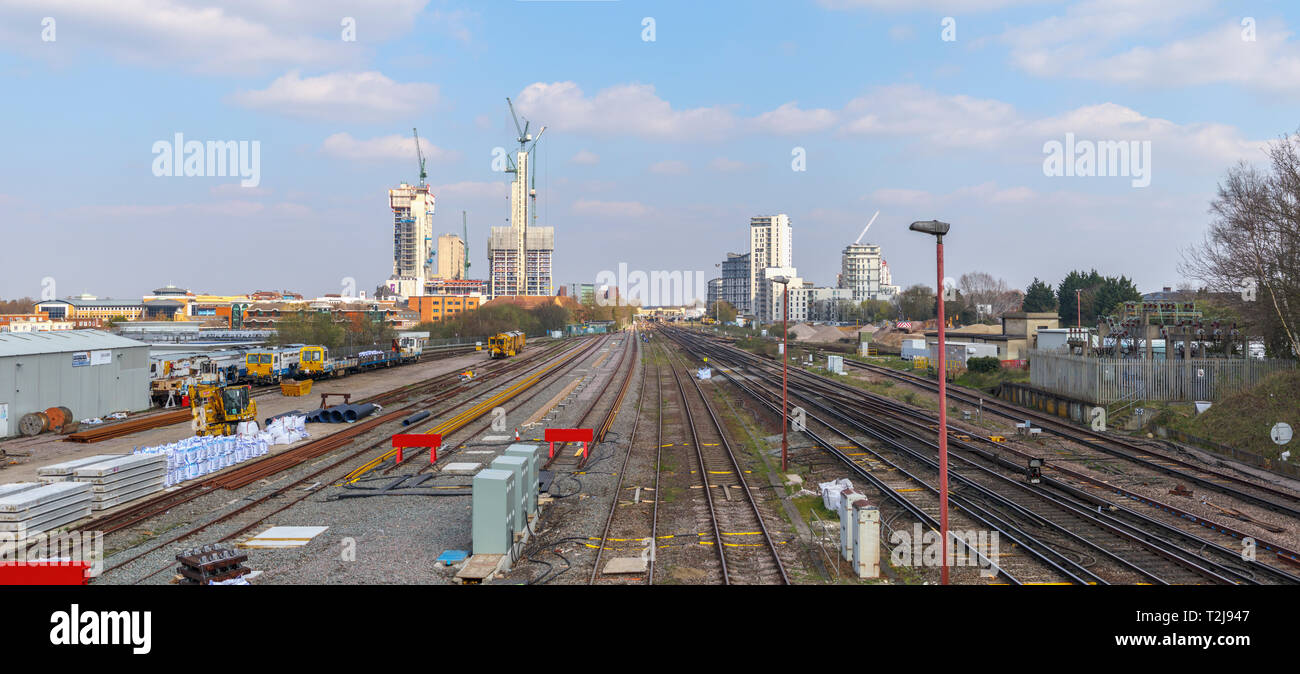 The changing skyline of Woking, Surrey: railway tracks lead into tower cranes and new high rise Victoria Square retail development in the town centre Stock Photo
