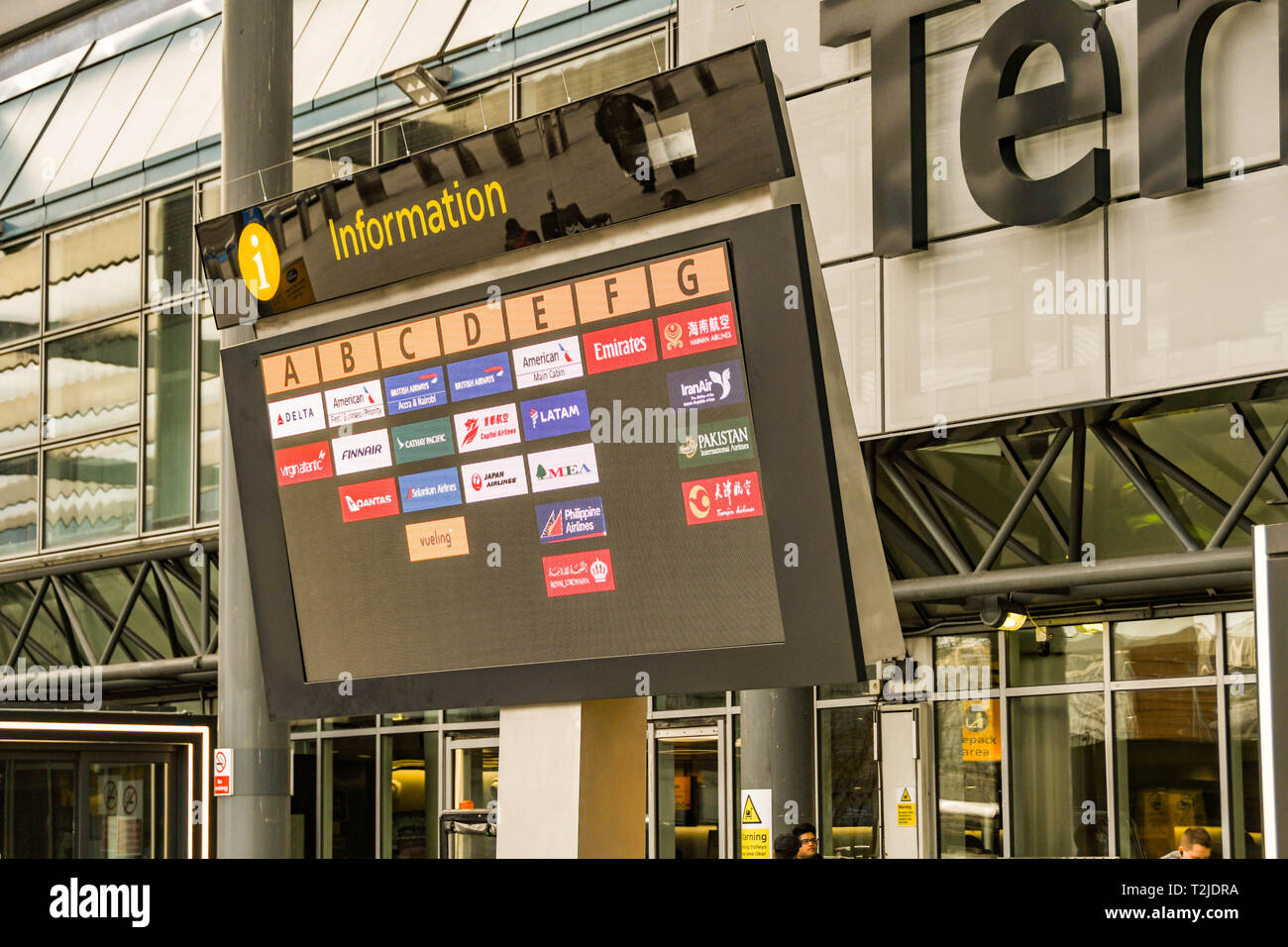 LONDON HEATHROW AIRPORT, ENGLAND - FEBRUARY 2019:  Airline logos showing on an electronic display screen outside London Heathrow Airport Terminal 3 Stock Photo