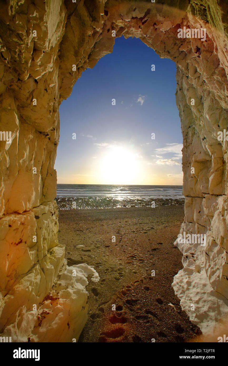 View of a sunset from a cave in the chalk cliffs near Beachy Head, Eastbourne, East Sussex, UK Stock Photo
