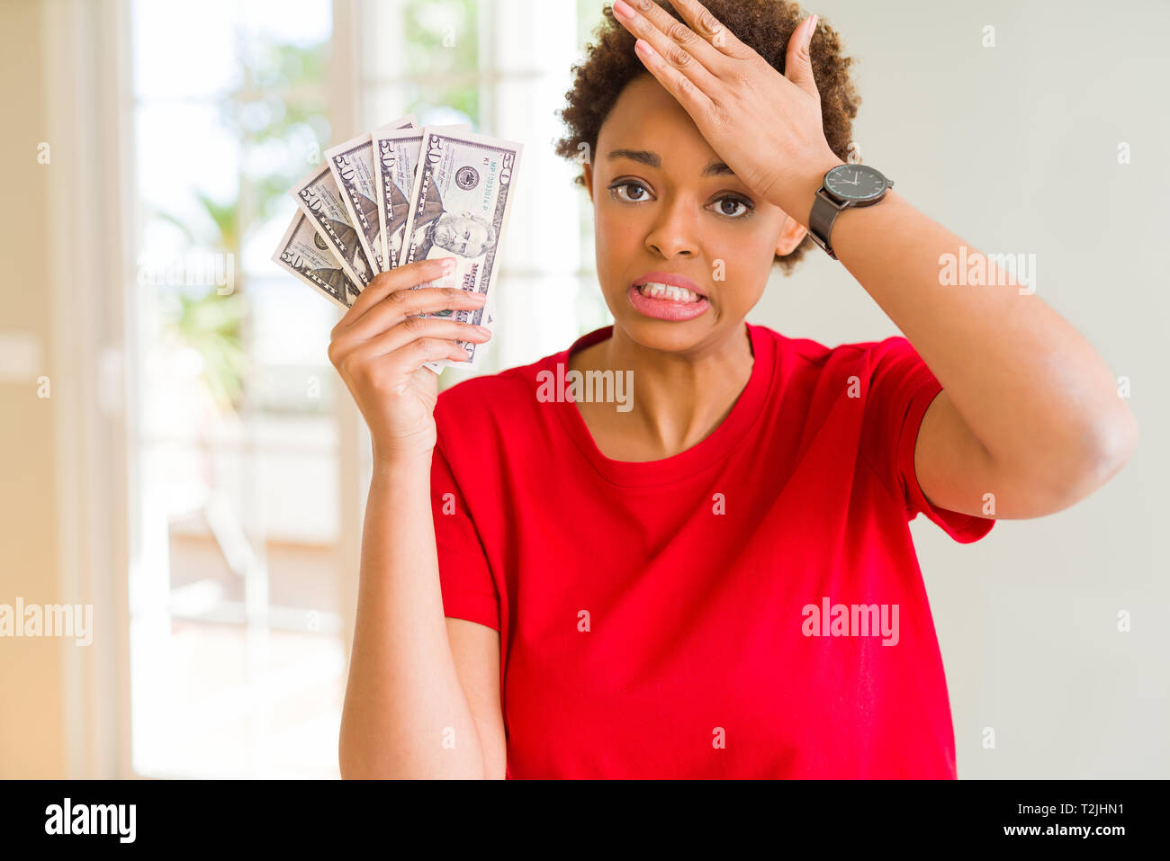 Young african american woman holding bank notes of fifty dollars ...