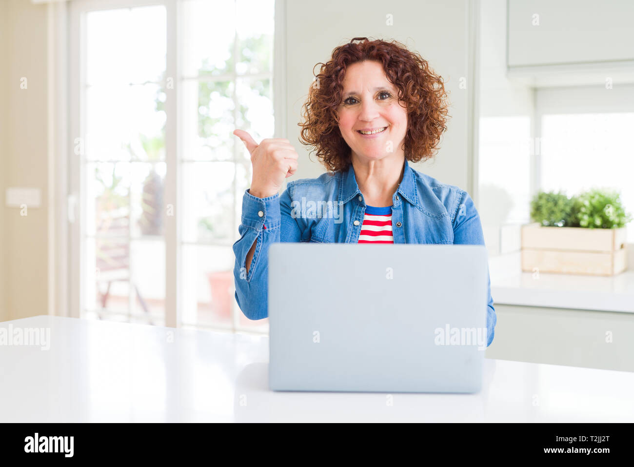 Senior woman working using computer laptop pointing and showing with ...
