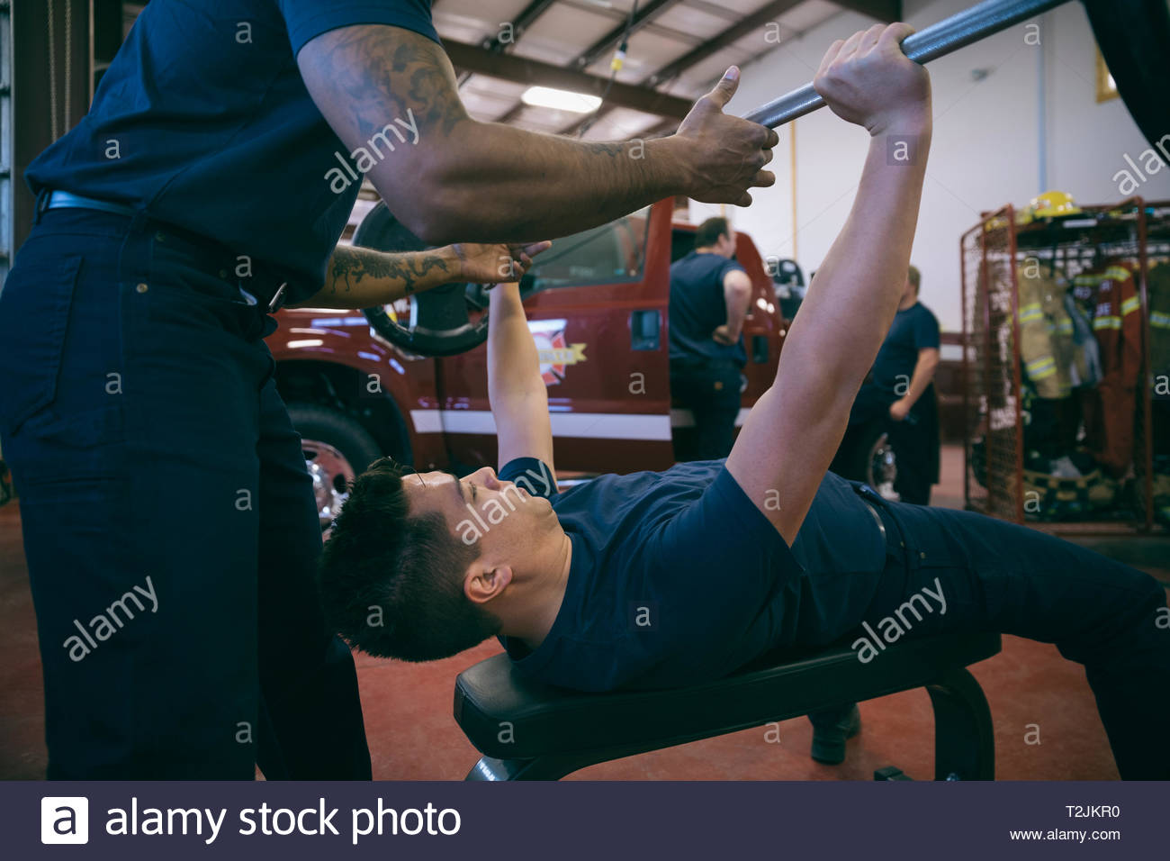 Firefighters weightlifting in fire station Stock Photo Alamy