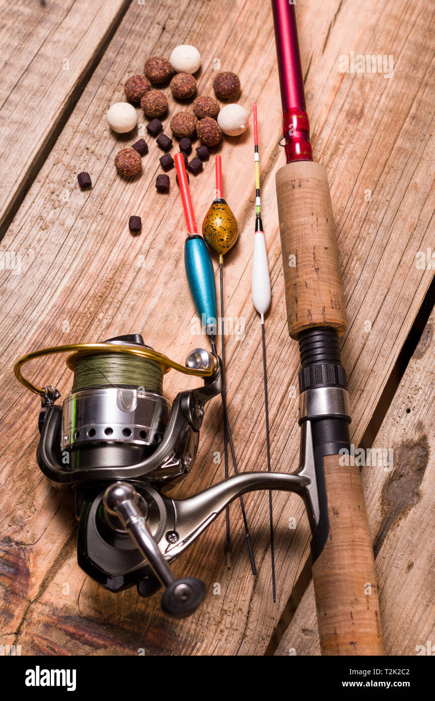 Fishing rod with a cortical handle and a fishing reel. A variety of floats.  Fishing bait from boilies and pellets. Vertical frame Stock Photo - Alamy