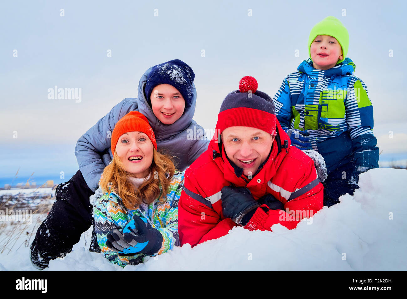 Portrait of a family with four people having fun in the snow. Dad, mom and two sons in winter day outdoor Stock Photo