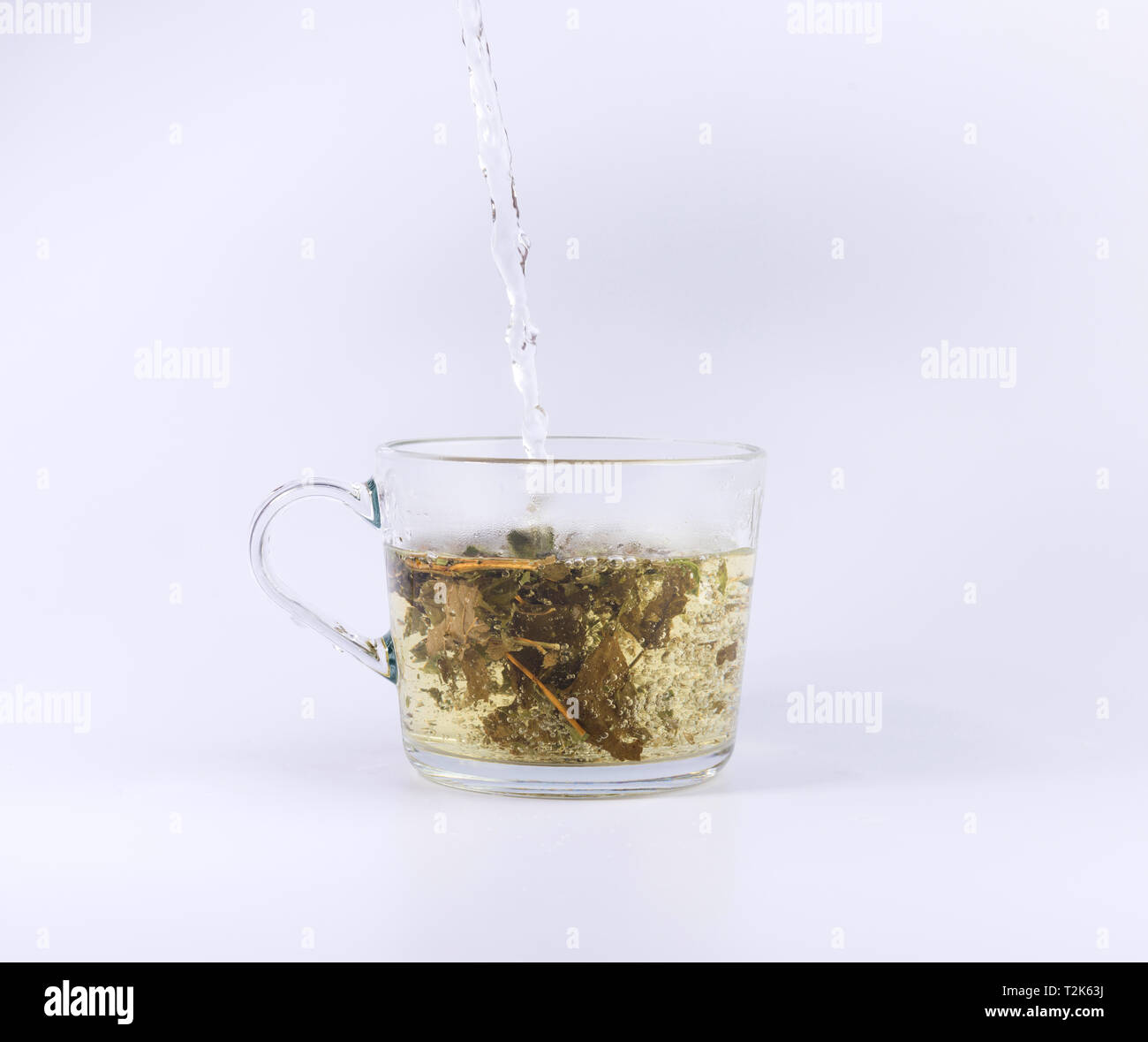 pouring hot water to the glass cup with tea, isolated on white background Stock Photo Alamy