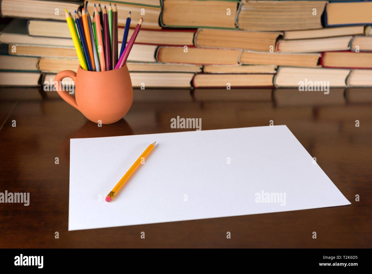 Paper and pencils on the wooden table, books background Stock Photo