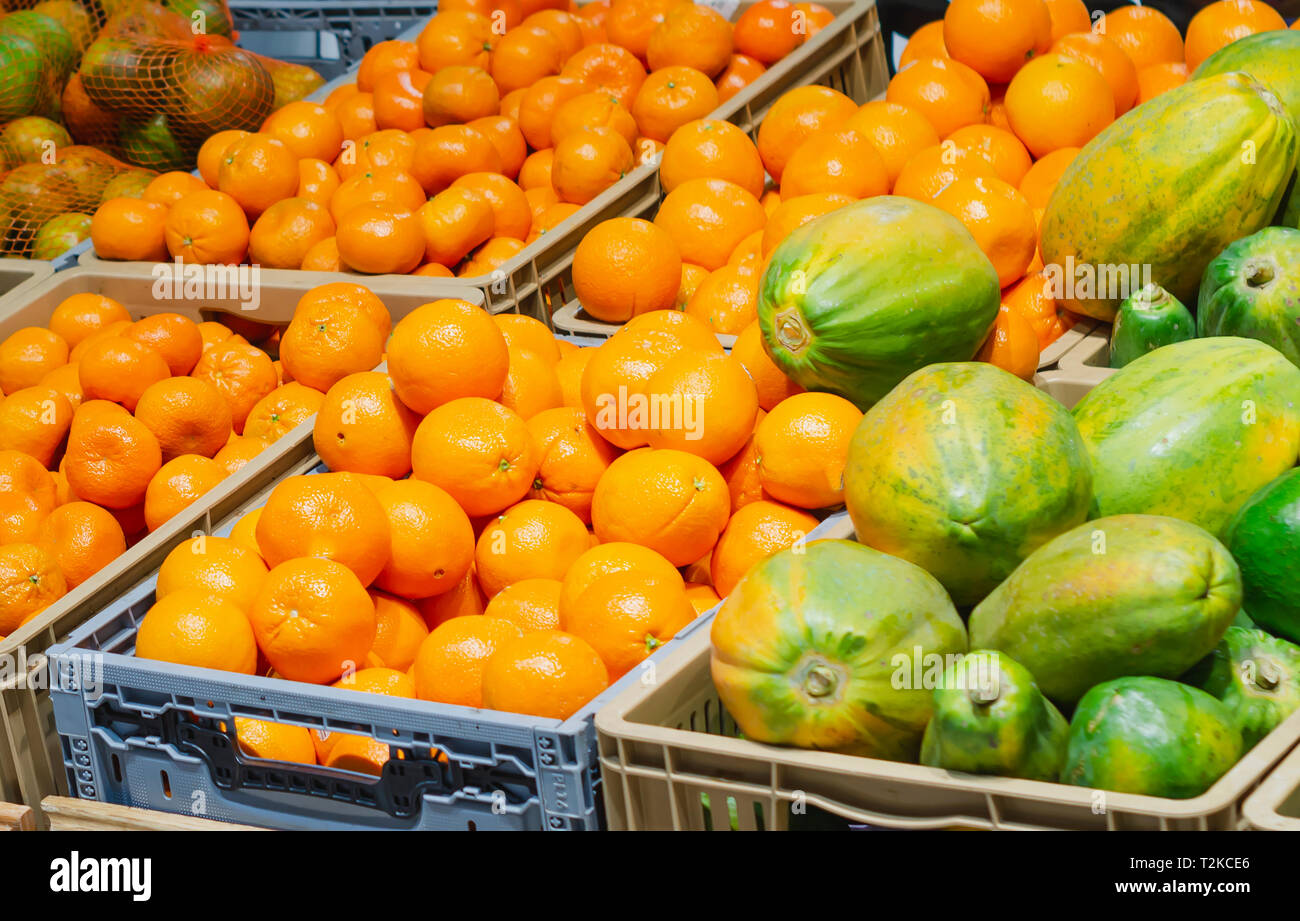 orange tangerines and papayas in a market put up for sale Stock Photo
