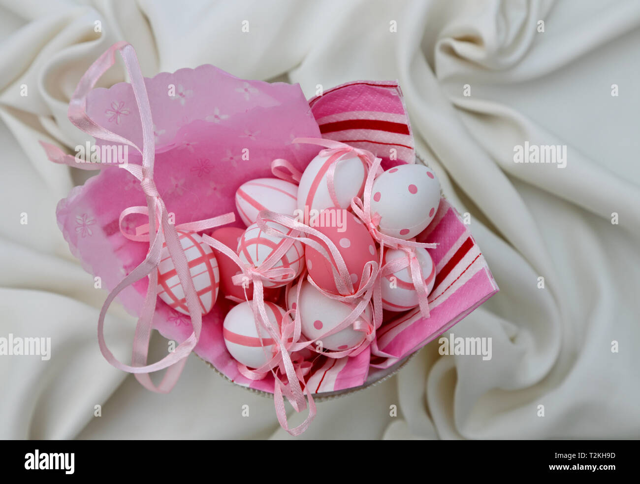 Small pink and white easter eggs on a white textile background Stock Photo