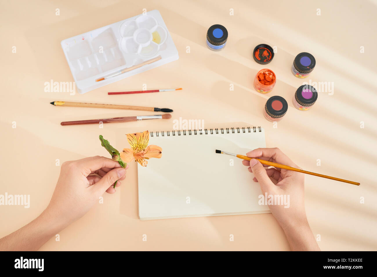 women's hand with brush drawing on notepad. Creation process of