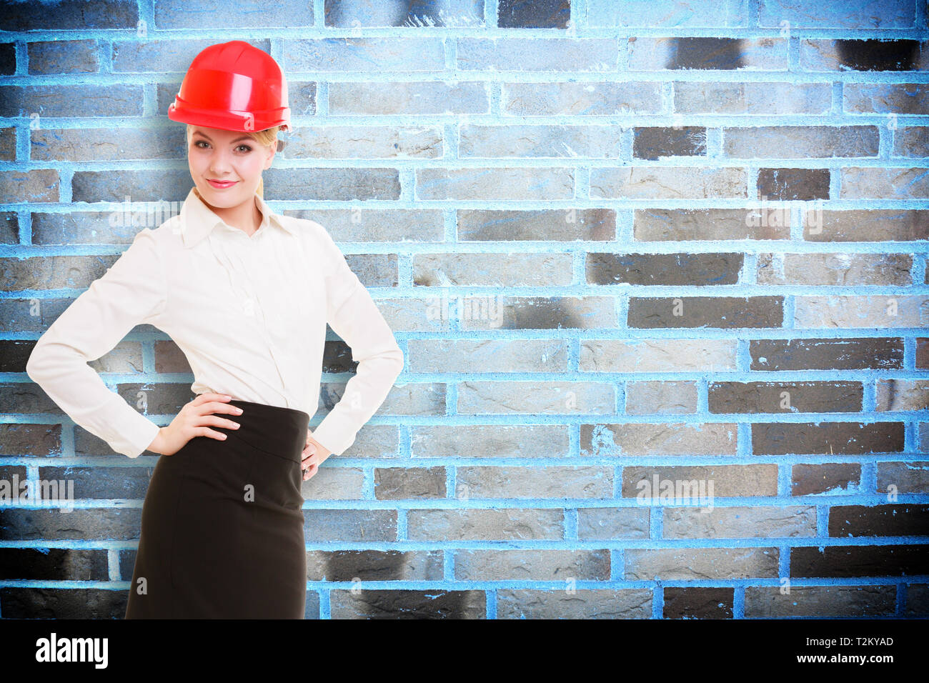 Portrait of attractive female engineer. Woman architect in red safety ...