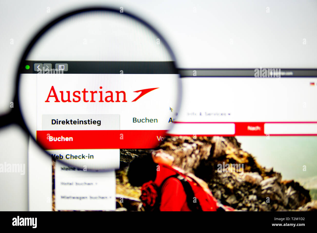 Air carrier Austrian website homepage. Austrian Air logo visible through a magnifying glass. Stock Photo