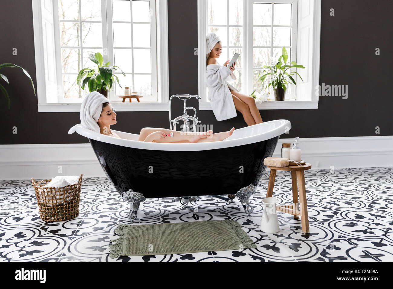 Cute young women dressed in white dressing gowns and towels on the head