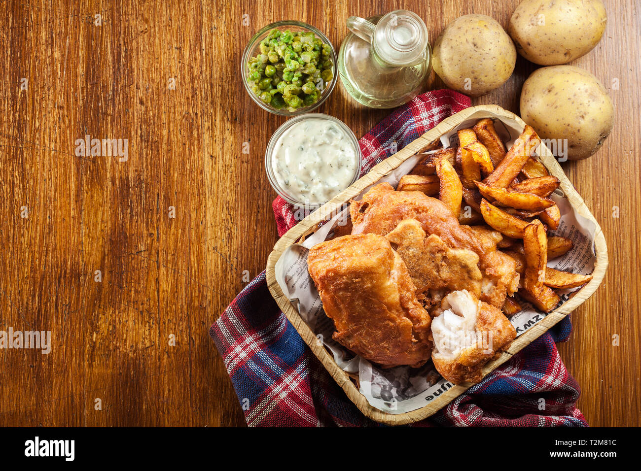 Traditional fish in beer batter and chips served on basket. Top view Stock Photo