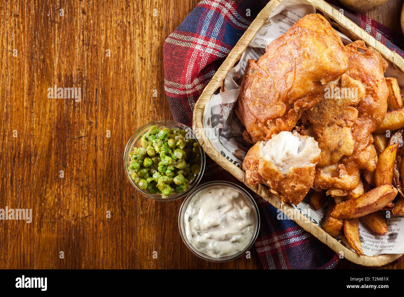 Traditional fish in beer batter and chips served on basket. Top view Stock Photo