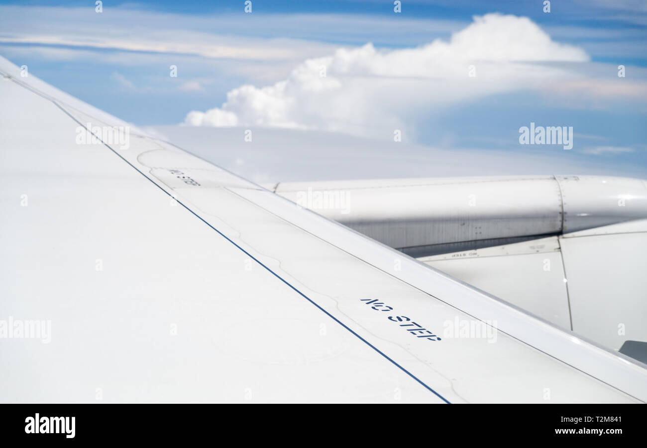 No step signs on commercial airplane wing, airplane in flight, shot through the window. Stock Photo
