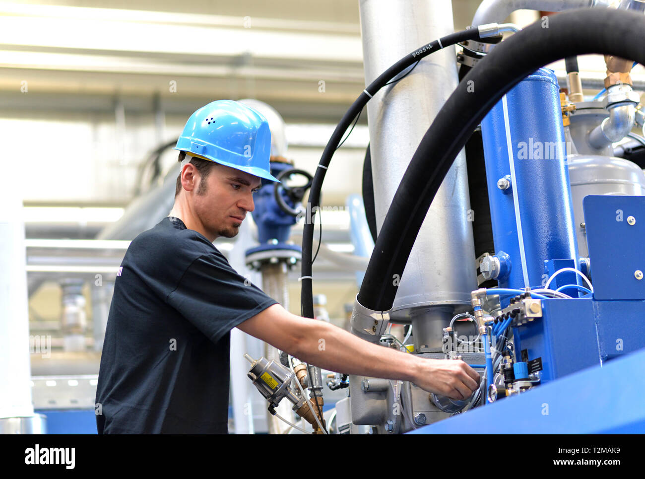 operator repairs a machine in an industrial plant with tools