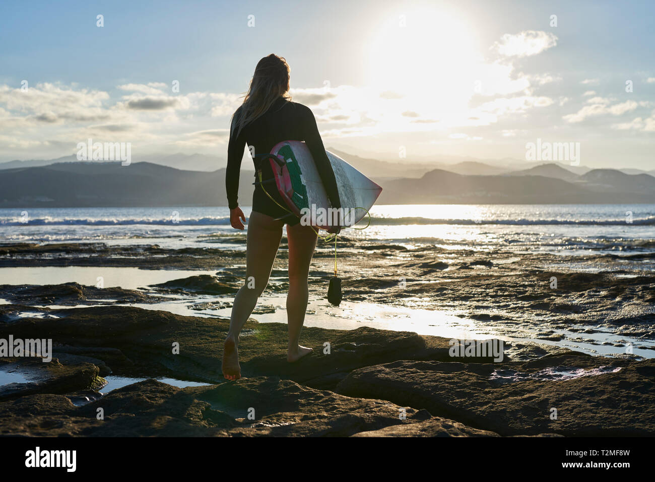 Surfer with surfboard on beach Stock Photo