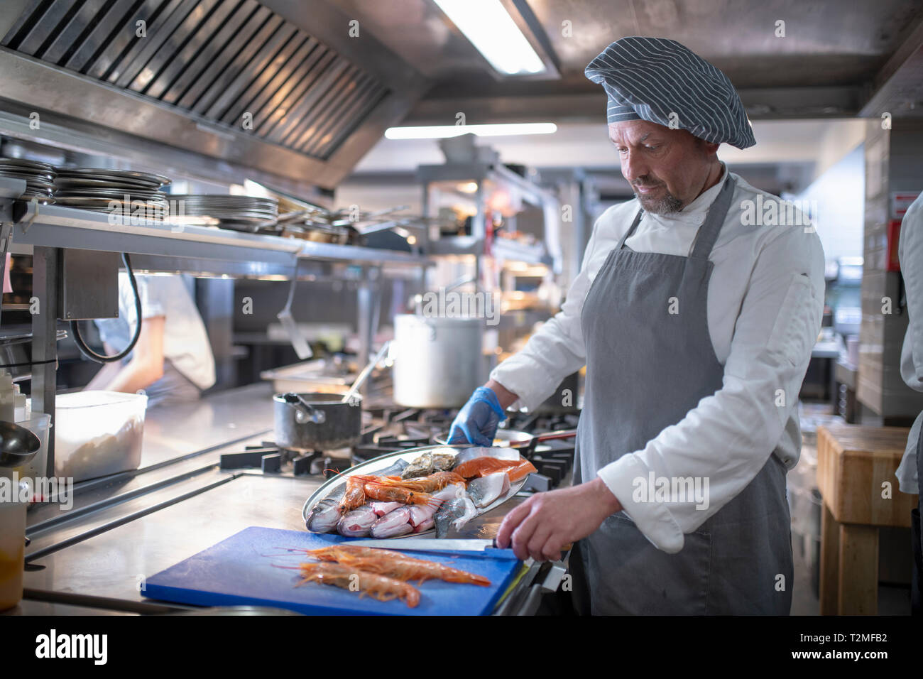 Chef preparing seafood dish in Italian restaurant kitchen Stock Photo