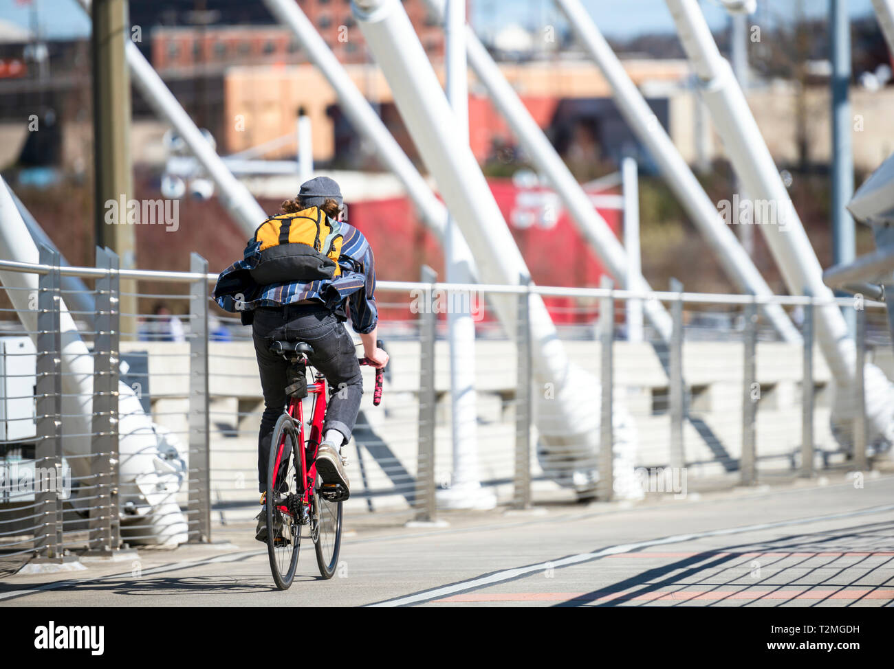 Man rides a bike on the bridge go to place of work preferring active healthy lifestyle and an alternative environmentally friendly mode of transport i Stock Photo