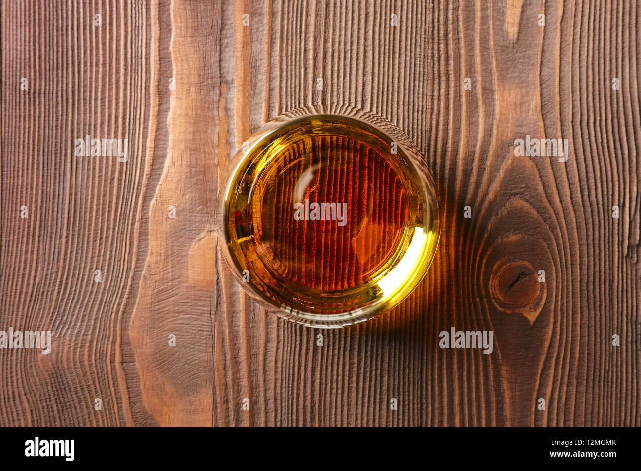 Snifter glass with pure whiskey on wooden table Stock Photo