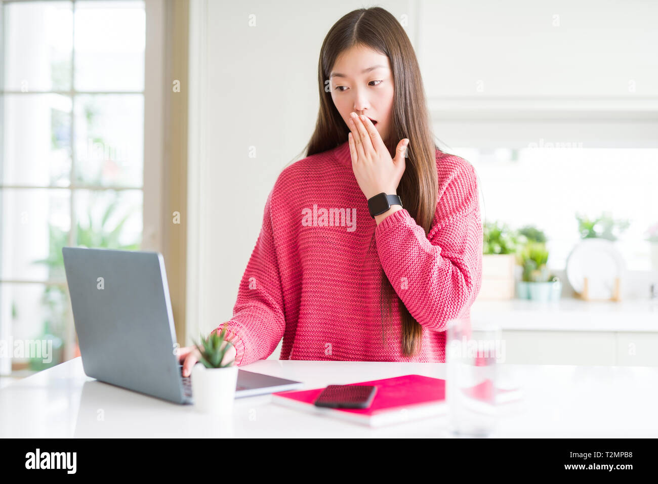 Beautiful Asian woman working using computer laptop cover mouth with ...