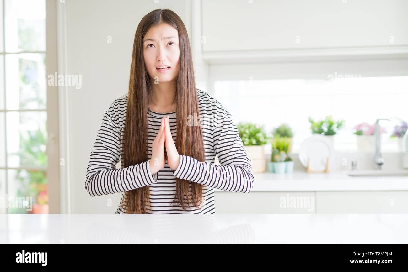 Hope Expression Beautiful Asian woman wearing stripes sweater begging and praying with ...