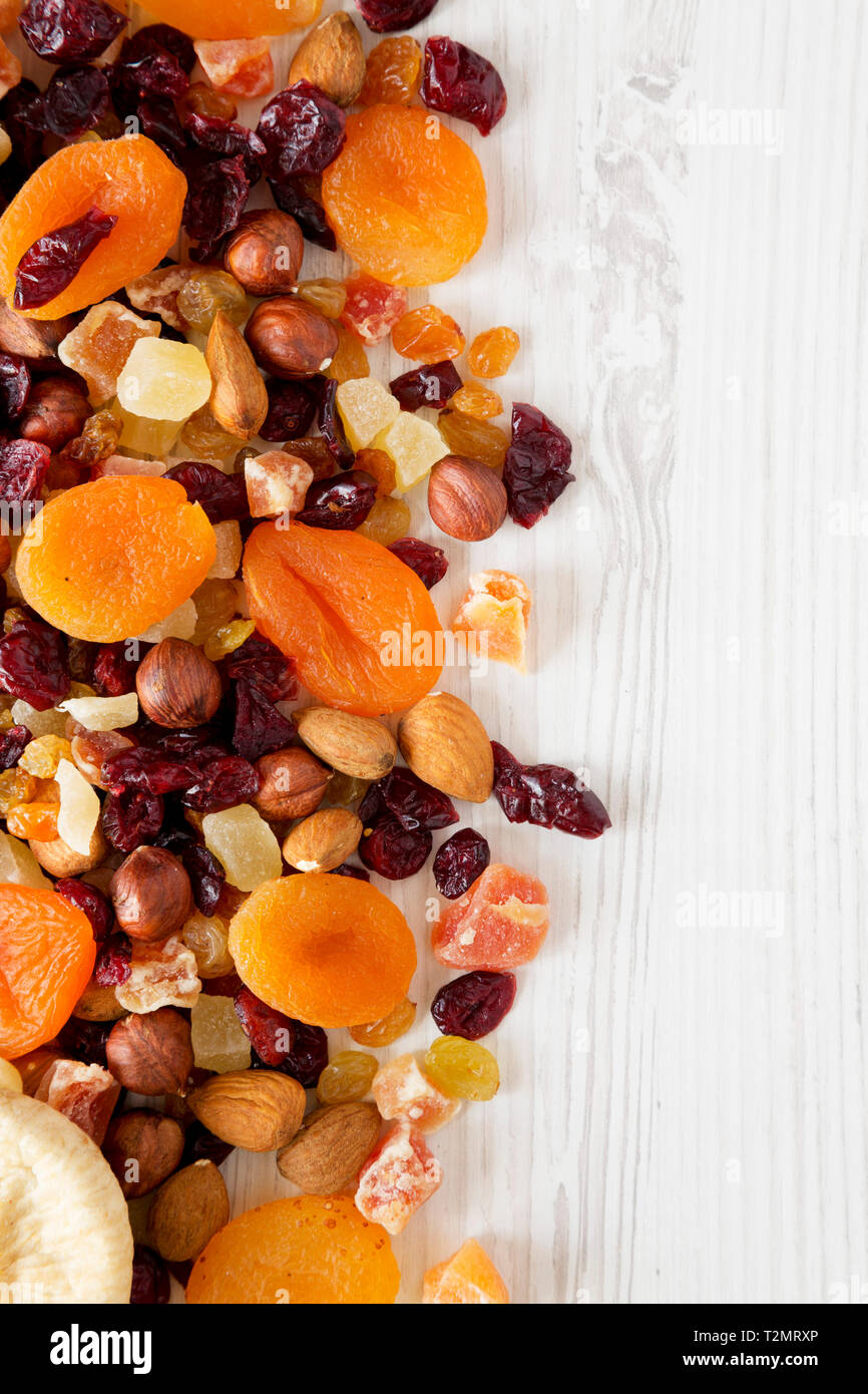 Dried fruits and nut mix on white wooden surface, top view. Overhead, from above, flat lay. Copy