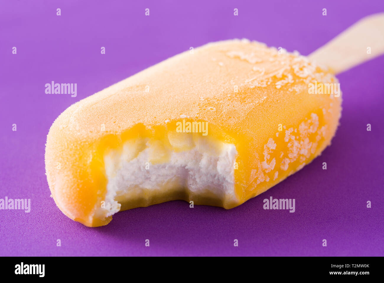 Orange popsicle on violet background Stock Photo