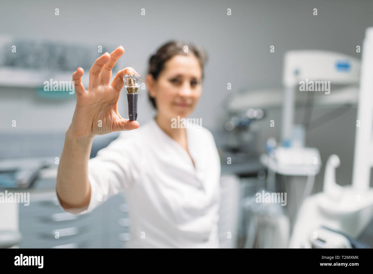 Female dentist shows tooth pin, dental clinic, professional prosthetic dentistry, stomatology cabinet, odontology Stock Photo