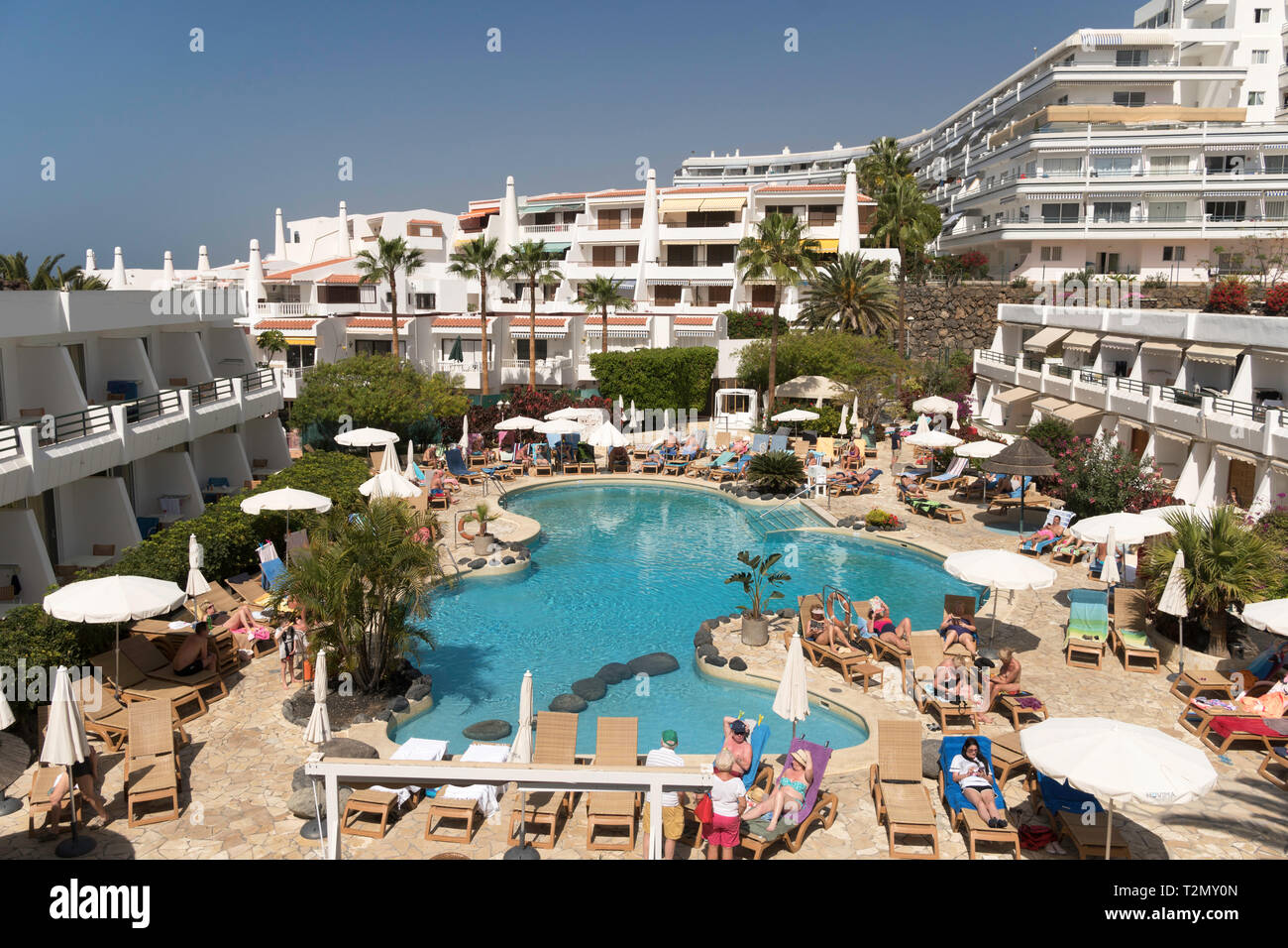 People sunbathing around the swimming pool of the Hovima Panorama Hotel in Costa Adeje, Santa Cruz de Tenerife, Spain Stock Photo