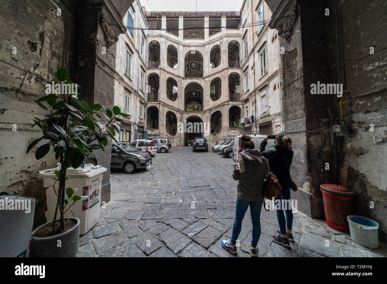 Young female tourists takes a photo of the astonishing stairs of palazzo Sanfelice, Naples, rione sanità Stock Photo