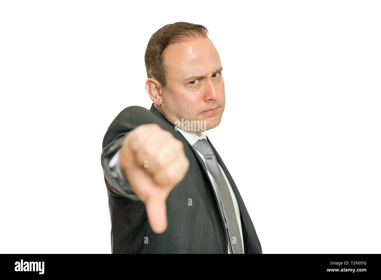 A portrait of a stern, angry business man giving a thumbs down signal on a white background with copy space. Stock Photo