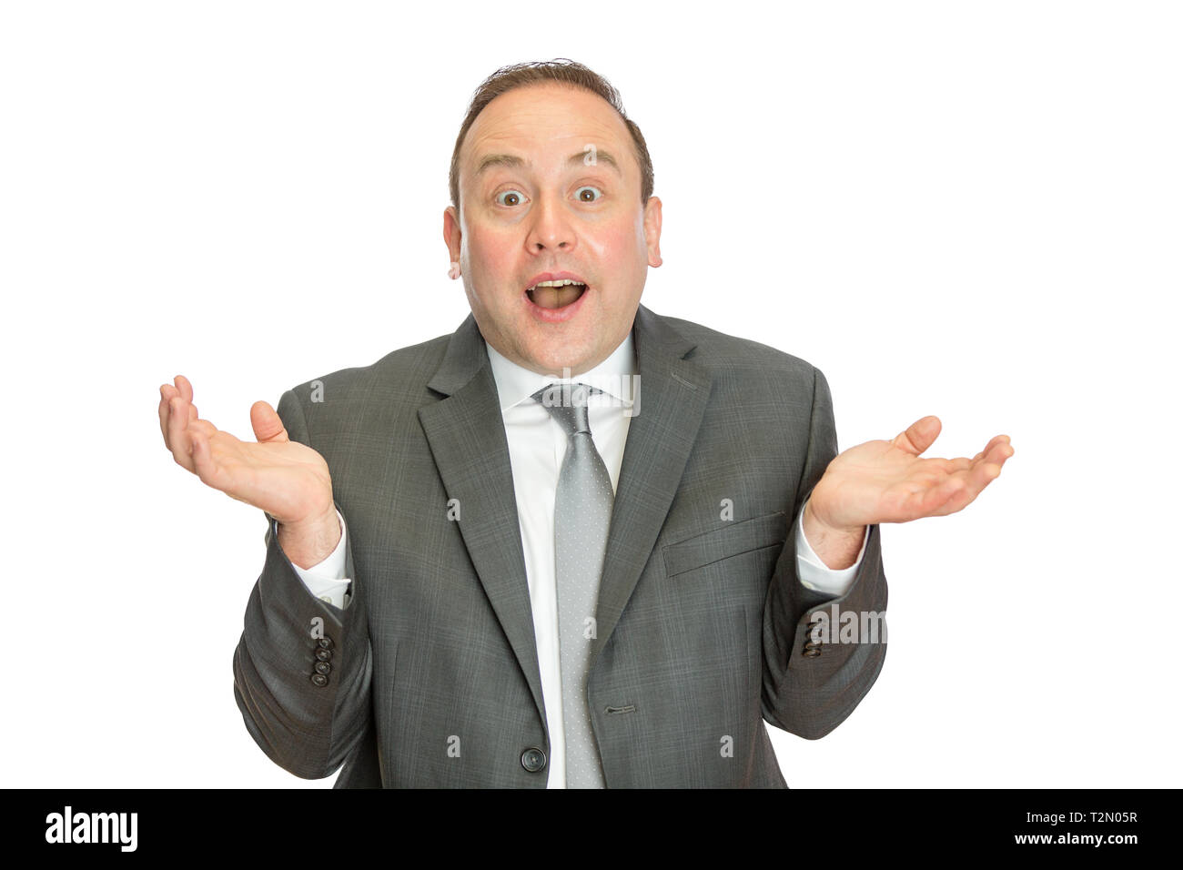 A portrait of a funny, comical business man in suit shrugging with a white background and copy space. Stock Photo