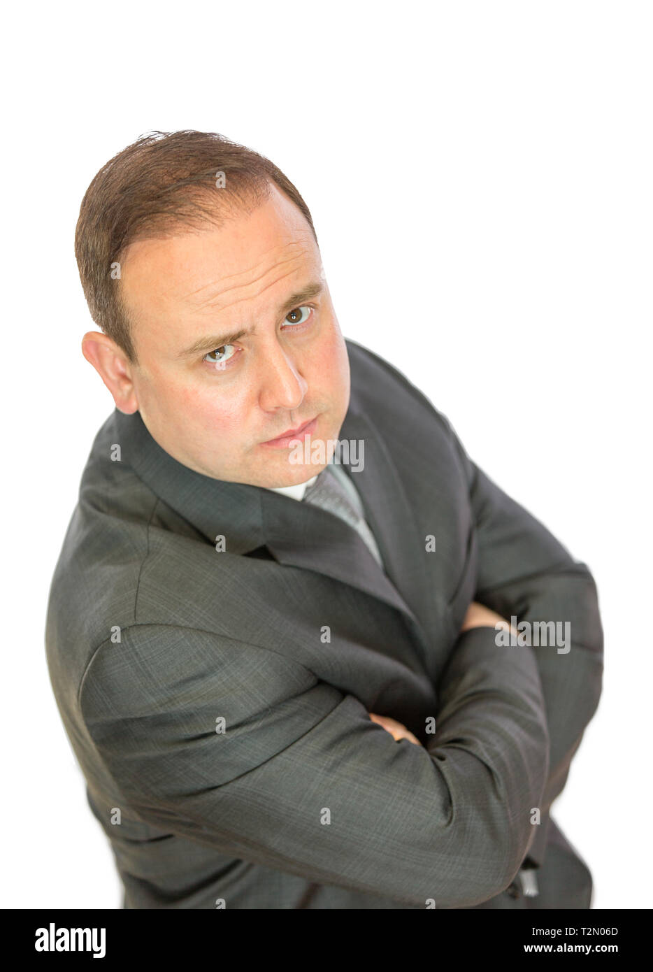 A serious-looking, concerned businessman with crossed arms on a white background with copy space. Stock Photo