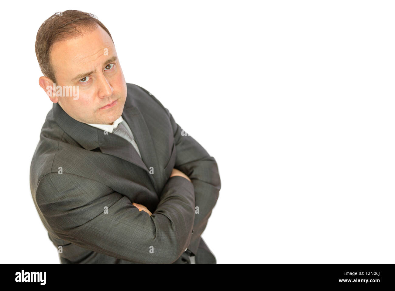 A serious-looking, concerned business manager with folded arms on a white background with copy space. Stock Photo