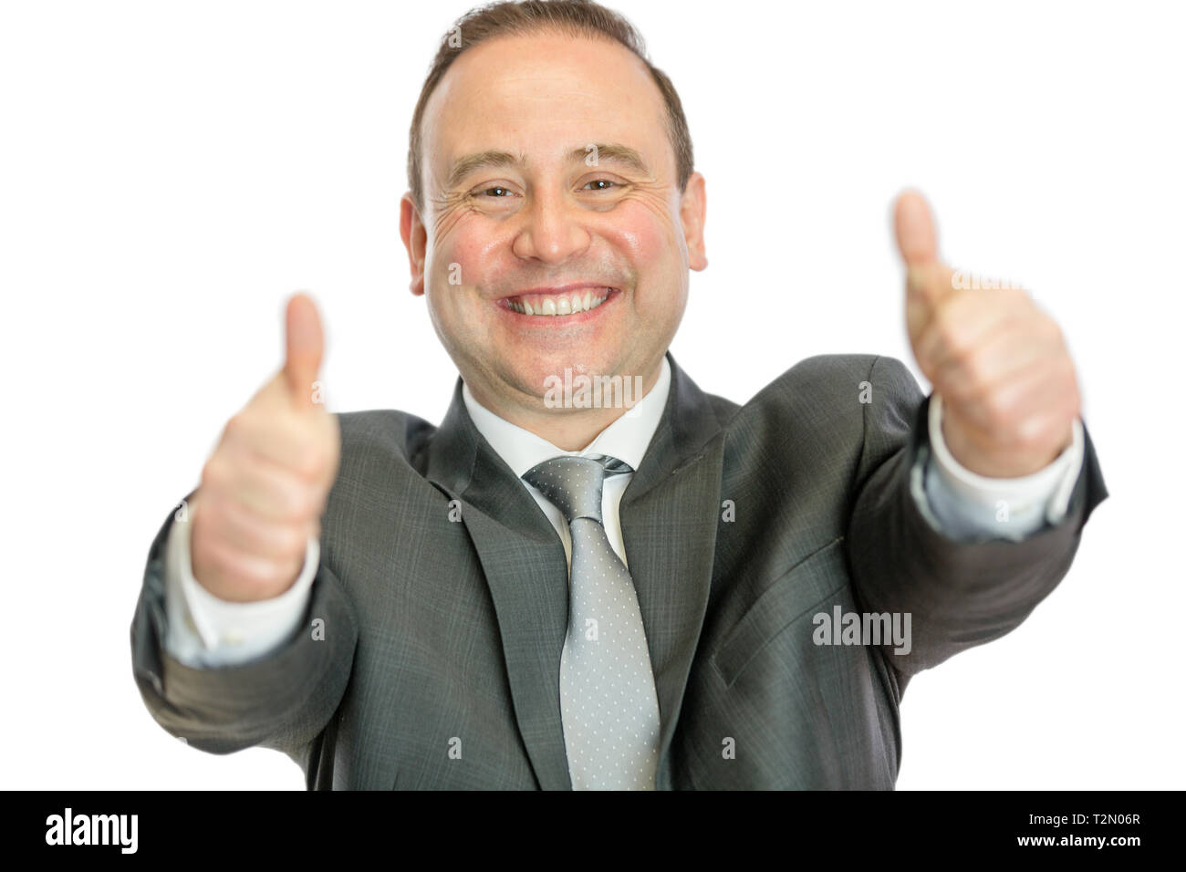 A happy, excited, mature businessman giving thumbs up signals with both hands on a white background with copy space. Stock Photo
