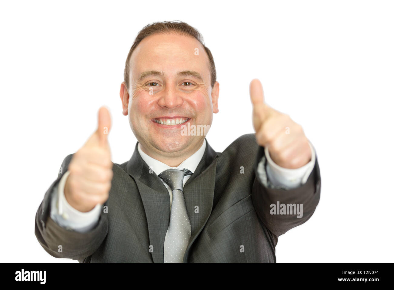 A happy, enthusiastic, mature businessman giving thumbs up signals with both hands on a white background with copy space. Stock Photo