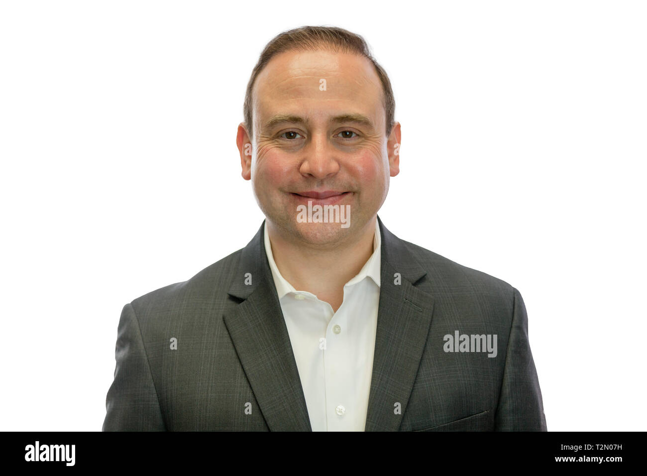 A portrait of a happy, mature businessman wearing a dark grey suit with a white background and copy space. Stock Photo