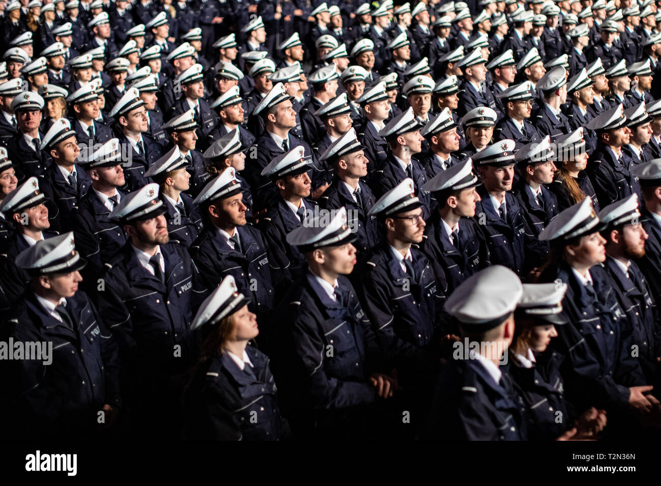 Cologne, Germany. 03rd Apr, 2019. 03 April 2019, North Rhine-Westphalia, Köln: Candidate commissioners stand in front of their chairs during the swearing-in ceremony. 2300 Commissioner candidates of the 2018 police recruitment year have taken their oath of allegiance. Photo: Marcel Kusch/dpa Credit: dpa picture alliance/Alamy Live News Stock Photo