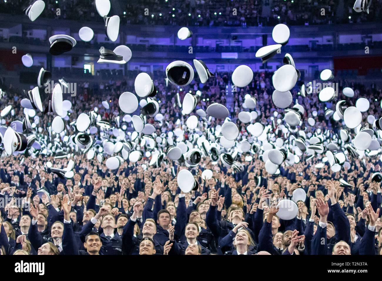 Cologne, Germany. 03rd Apr, 2019. 03 April 2019, North Rhine-Westphalia, Köln: Commissioner candidates throw their caps up after swearing in. 2300 Commissioner candidates of the 2018 police recruitment year have taken their oath of allegiance. Photo: Marcel Kusch/dpa Credit: dpa picture alliance/Alamy Live News Stock Photo
