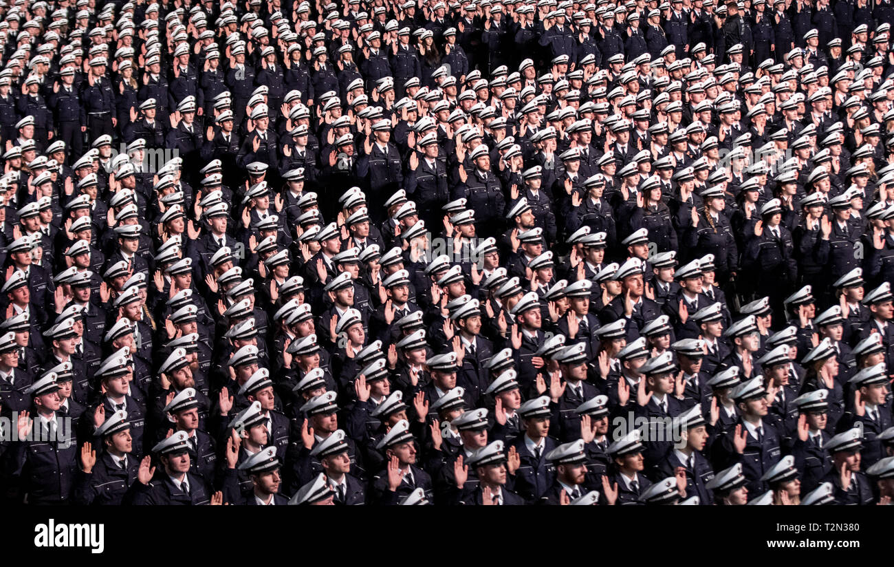 Cologne, Germany. 03rd Apr, 2019. 03 April 2019, North Rhine-Westphalia, Köln: Commissioner candidates hold up their right hands during the swearing-in ceremony. 2300 Commissioner candidates of the 2018 police recruitment year have taken their oath of allegiance. Photo: Marcel Kusch/dpa Credit: dpa picture alliance/Alamy Live News Stock Photo