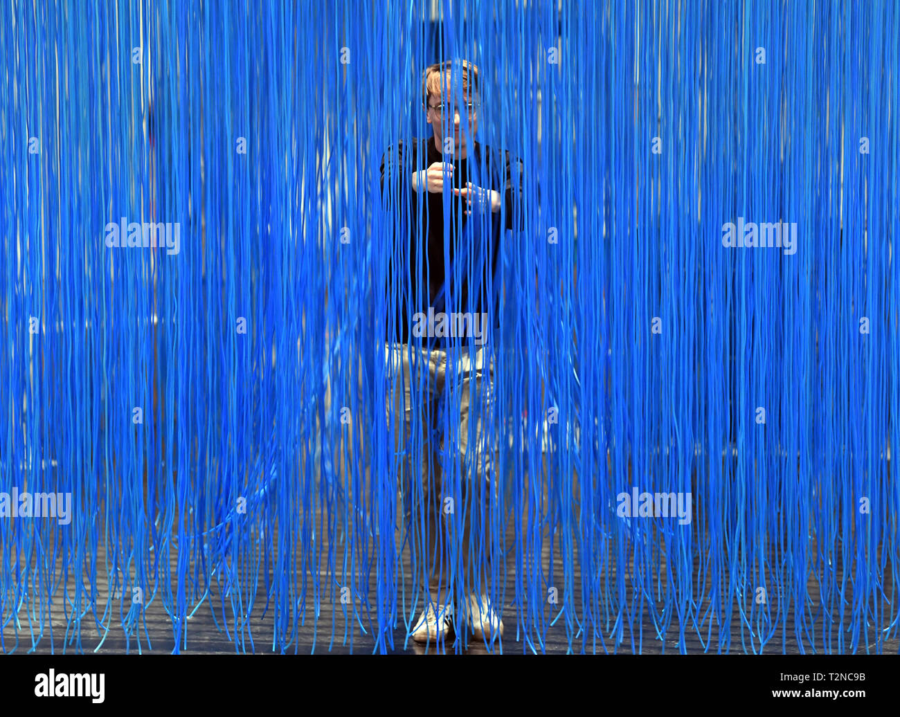 Karlsruhe, Germany. 03rd Apr, 2019. In the Center for Art and Media (ZKM) a person walks through the installation 'Penetrable BBL bleu' by Jesus Rafael Soto from 1999, which is part of the exhibition 'Negativer Raum. Skulptur und Installation im 20./21. Jahrhundert', which will be shown there from 06.04.2019 to 11.08.2019. Credit: Uli Deck/dpa/Alamy Live News Stock Photo
