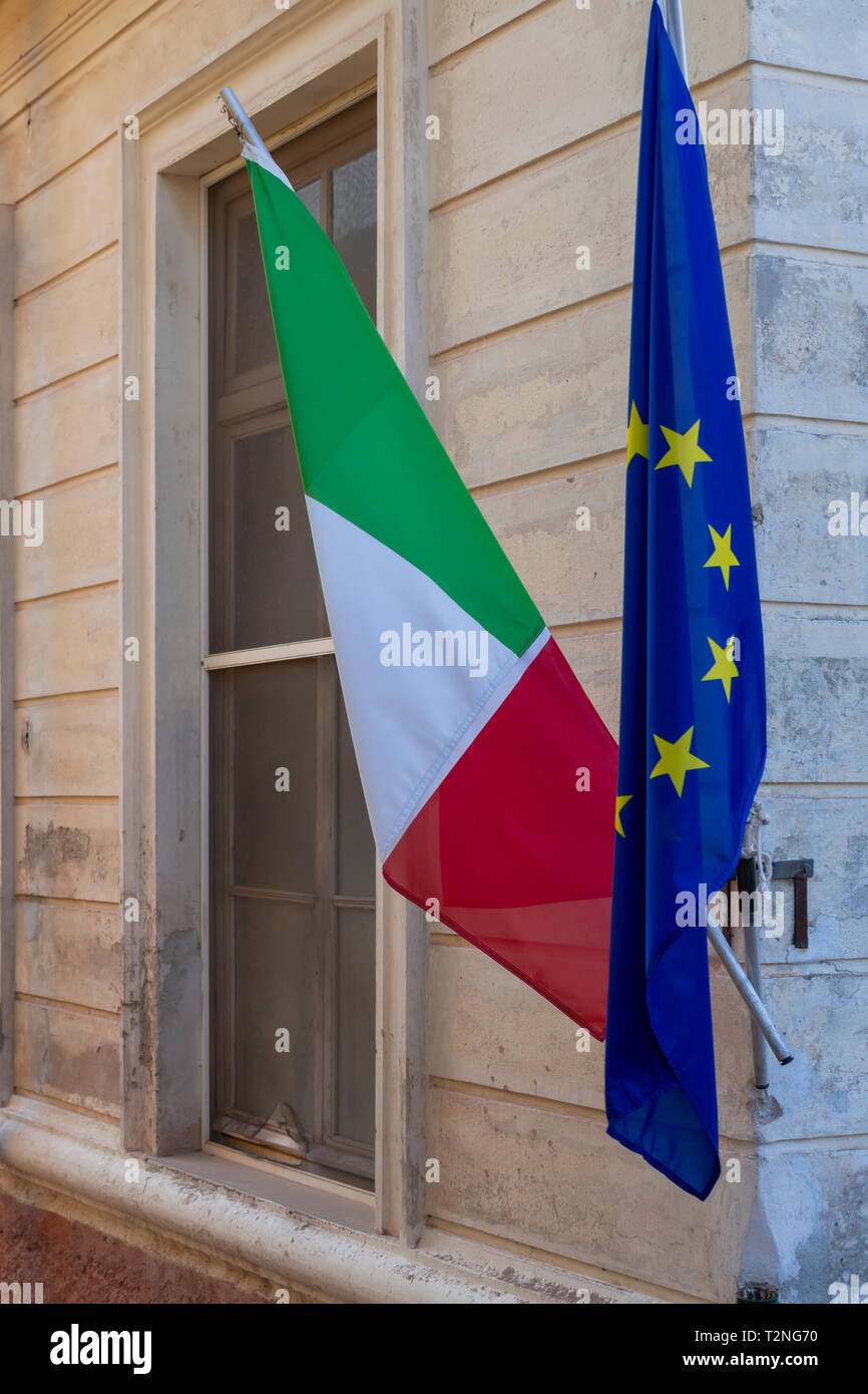 Photo of Italian and EU flags on flag poles. Drooping. Stock Photo