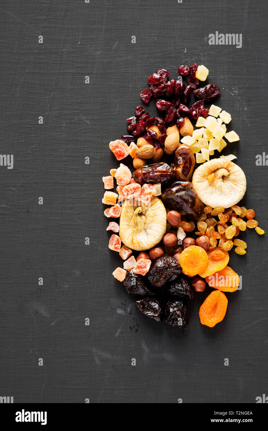 Dried fruits and nut mix on black surface, top view. Overhead. Copy space Stock Photo Alamy