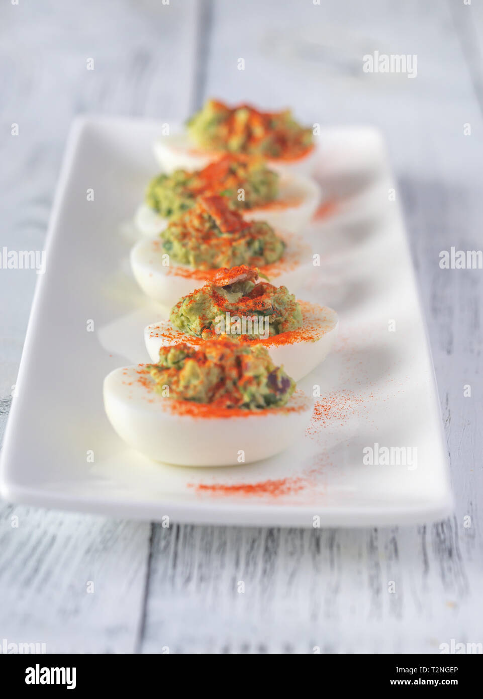 Guacamole and bacon deviled eggs on the white plate Stock Photo