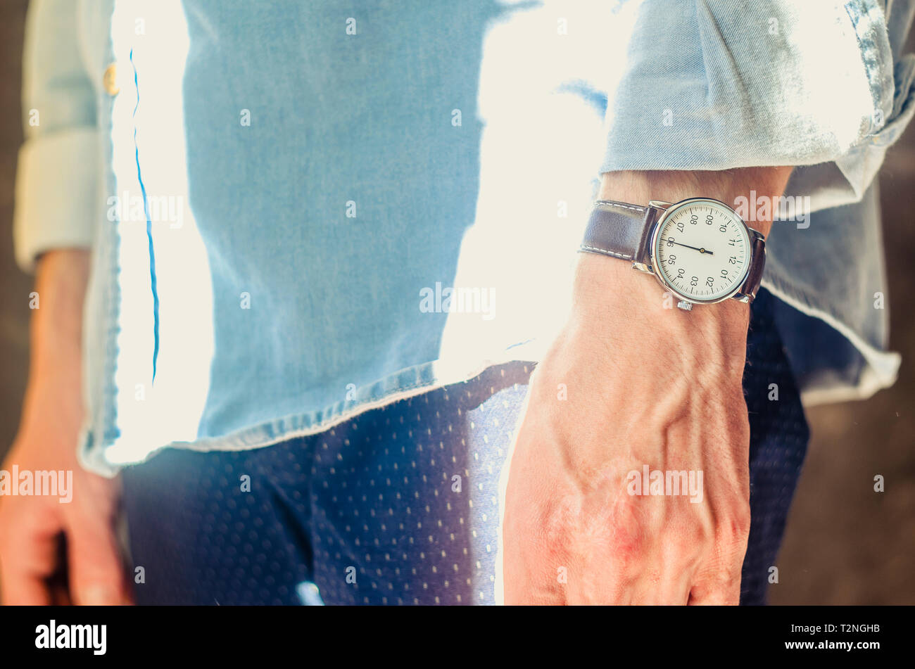 Close Up of a Men's Accessory Elegant Wrist Watches. Rolled Up Shirt Sleeves. Informal Casual Wear Concept Stock Photo